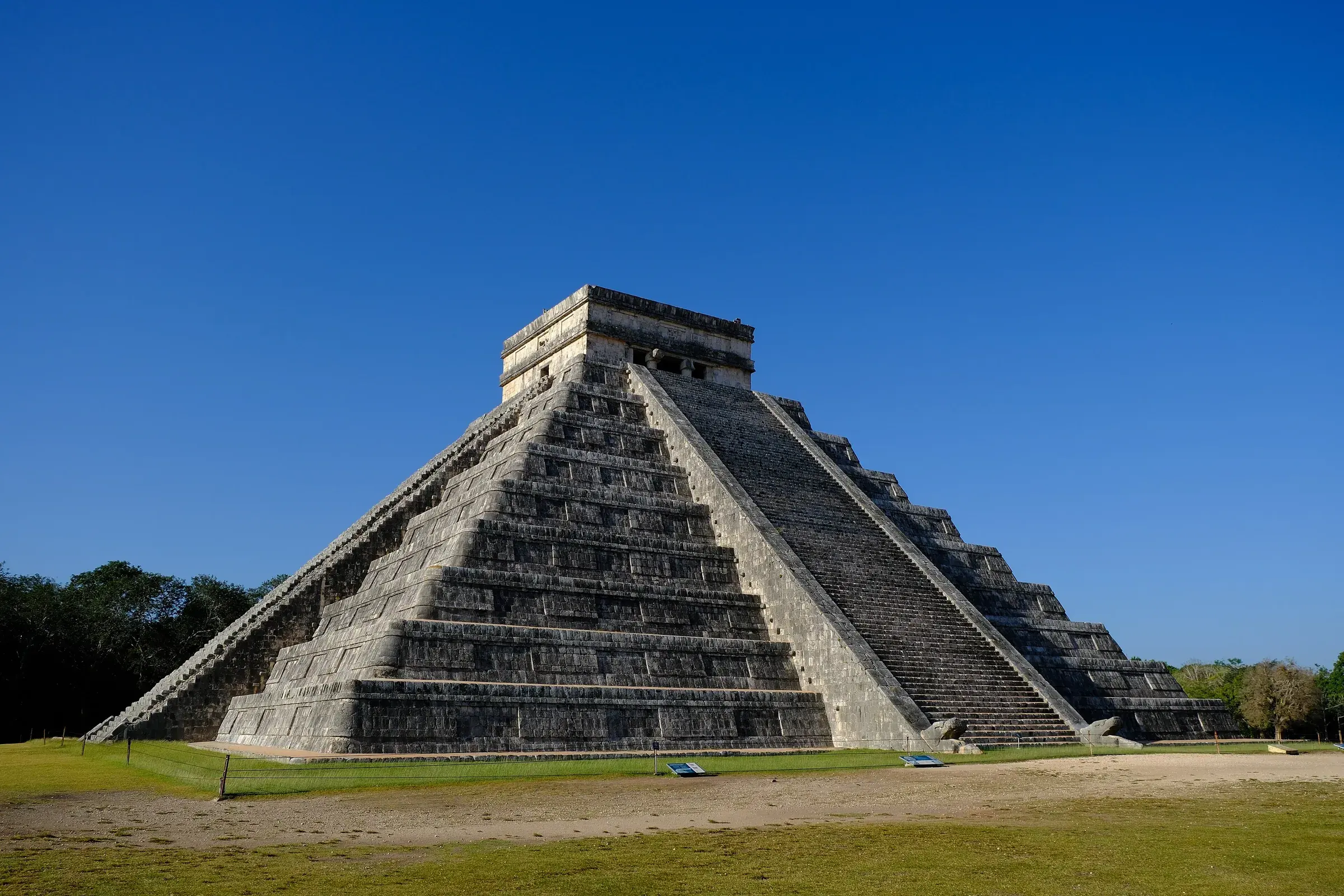 Pyramid of Kukulcán (El Castillo) at Chichén Itzá, with its stepped staircases under a deep blue sky