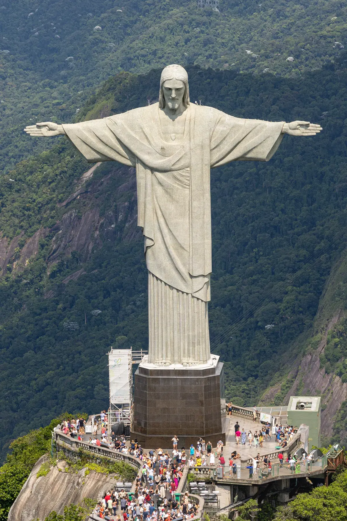 Aerial view of Christ the Redeemer with outstretched arms atop the Corcovado lookout, with the Tijuca Forest in the background